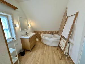 a bathroom with a tub and a toilet and a sink at Haus Schneekappe (Winterberg) in Winterberg