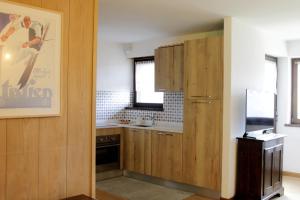 una cucina con armadi in legno e frigorifero di CASA SOFIA - Dolomiti Affitti a Cavalese