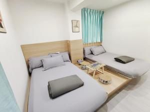 Habitación pequeña con 2 camas y mesa. en The Nap Tsim Sha Tsui, en Hong Kong