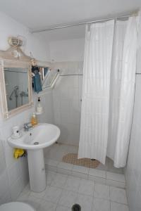 baño con lavabo y cortina de ducha en MARKOS' HOUSE, en Agiassos