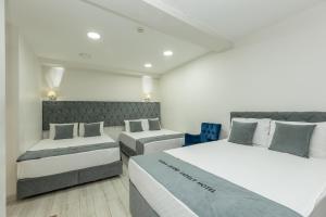 a room with three beds and a blue chair at BURSA GRAND FAMİLY HOTEL & SpA in Bursa