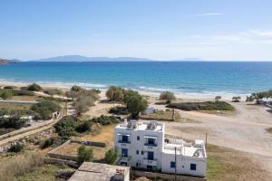 uma casa branca na praia junto ao oceano em MARKOS' HOUSE em Agiassos