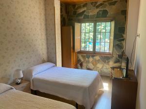 ポンフェラーダにあるHotel Rural Camino Medulasのベッド2台と窓が備わる客室です。