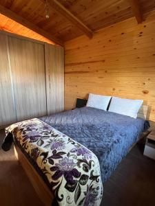 a bedroom with a bed in a wooden cabin at Charmant Chalet calme et moderne in Dar Mohammed Ould Haj Jilali