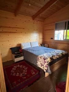 Un dormitorio con una cama en una cabaña de troncos en Charmant Chalet calme et moderne, en Dar Mohammed Ould Haj Jilali