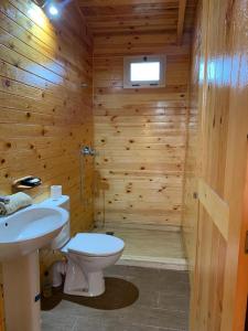 baño de madera con aseo y lavamanos en Charmant Chalet calme et moderne en Dar Mohammed Ould Haj Jilali