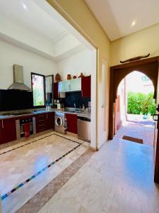 a kitchen with an open door to a kitchen with a washer at Entire villa with private pool in Marrakech in Marrakesh