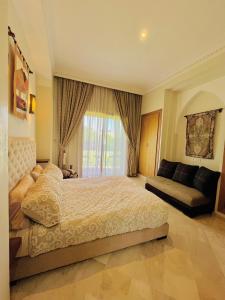 a bedroom with a bed and a window and a couch at Entire villa with private pool in Marrakech in Marrakesh +39 photos