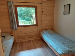a small room with a window in a log cabin at Willa Ozark in Zawóz