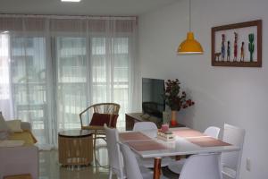 a living room with a dining table and chairs at Apartamento Confortável - Porto das Dunas - Perto do Beach Park in Aquiraz