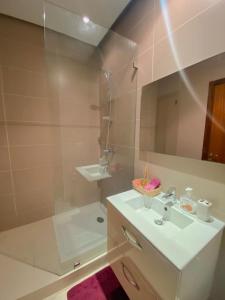 a white bathroom with a sink and a shower at Luxury résidence Taj Nouaceur in Nouaseur