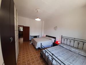 1 dormitorio con 2 camas y pasillo en Villetta Elena, en Melissano