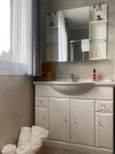 uma casa de banho com lavatório, espelho e toalhas em APARTAMENTO NIK en casa chalet con parking y jardin em Erandio