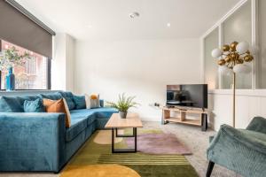 a living room with a blue couch and a tv at Modern Studio Apartment in Central Rotherham in Rotherham