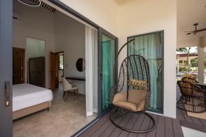 a room with a balcony with a chair and a bed at Sixth Sense Phangan Villas in Hinkong