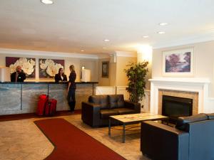 a woman standing in a living room with a fireplace at West Edmonton Mall Inn in Edmonton