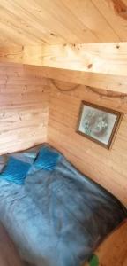 Bett in einem Holzzimmer mit einem Bild in der Unterkunft Chatka na Wzgórzu, Staw z możliwością łowienia ryb, Cisza, Spokój in Barczewo