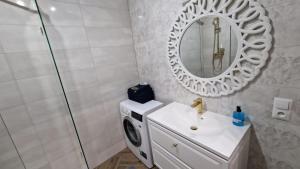a bathroom with a washing machine and a sink at APARTAMENT JARACZA 28 nr 18 in Słupsk +22 photos