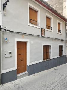 um edifício branco com uma porta castanha numa rua em Casa del Castillo em Caravaca de la Cruz