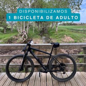 Una bicicleta estacionada en un puente de madera con las palabras diazepam bicycleride en T1 Lagoa Santo André, en Costa de Santo André