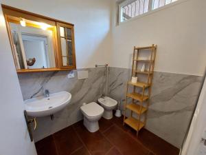 uma casa de banho com um lavatório, um WC e uma prateleira em Ai Cerri em Cinquale