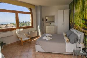 sypialnia z łóżkiem i dużym oknem w obiekcie Home Suite Home w mieście Cavaion Veronese