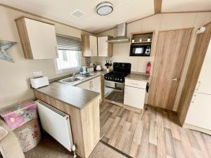 a small kitchen with a sink and a stove at Coastal Retreat a gorgeous 3 bedroom Caravan B46 in Everton