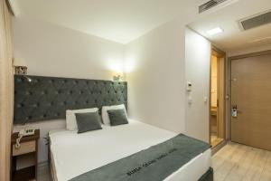 伯薩的住宿－BURSA GRAND FAMİLY HOTEL & SpA，一间卧室配有一张大床和绿色床头板