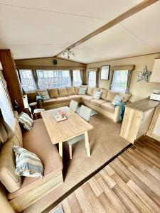a living room with a couch and a table at Coastal Retreat a gorgeous 3 bedroom Caravan B46 in Everton