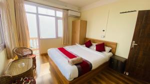 a bedroom with a large bed with red and white sheets at Himalayan Sunrise in Dhulikhel