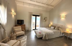 een slaapkamer met een bed, een stoel en een televisie bij Résidence & Hôtel Aria Marina in Propriano