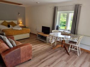 a bedroom with a bed and a table and a couch at Glyndwr Vineyard in Cowbridge