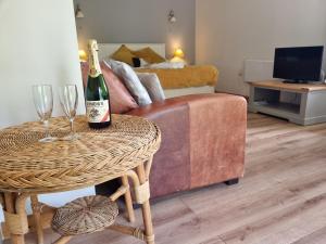 um quarto com uma mesa com uma garrafa de vinho e copos em Glyndwr Vineyard em Cowbridge