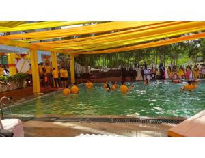 a group of people in the water in a swimming pool at Hotel Rishivan Resort, Khopoli in Khopoli