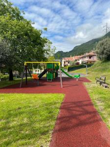 un parque con parque infantil con tobogán y banco en Casa46, en Costa Volpino