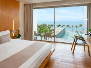 ein Schlafzimmer mit Bett und Blick auf das Meer in der Unterkunft Explorar Koh Samui - Adults Only Resort and Spa in Mae Nam