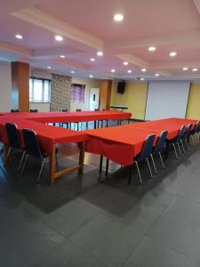 einen Konferenzraum mit roten Tischen und Stühlen in der Unterkunft 3PUTRA HOTEL JAKARTA in Jakarta