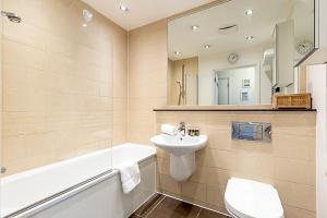 ein Badezimmer mit einem Waschbecken, einem WC und einer Badewanne in der Unterkunft Urban and Stylish Apartment in London