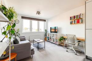 ein Wohnzimmer mit einem Sofa und einem Schreibtisch in der Unterkunft Urban and Stylish Apartment in London