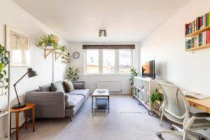 ein Wohnzimmer mit einem Sofa und einem Tisch in der Unterkunft Urban and Stylish Apartment in London