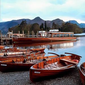 a group of boats sitting on the shore of a lake at Harvington House in Keswick