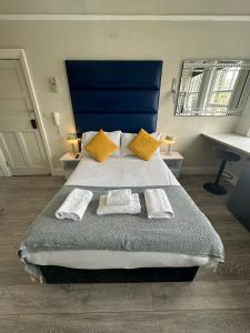- une chambre avec un grand lit et 2 serviettes dans l'établissement Apartments in the Heart of High Street Kensington, à Londres