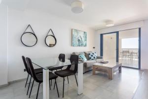 une salle à manger avec une table en verre et des chaises noires dans l'établissement Espectacular Terraza Altea Beach, à Altea
