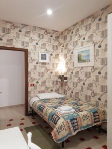 una camera con un letto e una parete con carta da parati di B&B Cactus a Giardini Naxos