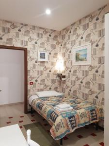 a bedroom with a bed and a wall with a wallpaper at B&B Cactus in Giardini Naxos