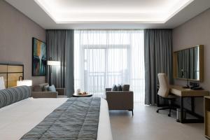 Djibouti Ayla Grand Hotel في جيبوتي: غرفة الفندق بسرير كبير ومكتب