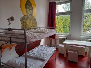 a room with two bunk beds and a large painting on the wall at instantSleep Backpackerhostel St Pauli in Hamburg