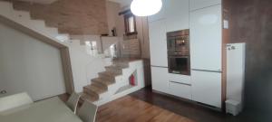 una escalera en una cocina con armarios blancos en Casa Vacanze Angelo, en Ortona