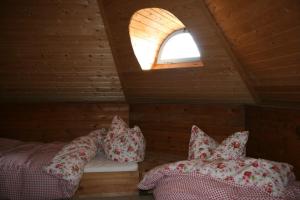 a room with two beds in a wooden cabin with a window at Mühle Beckenkrug in Varchentin