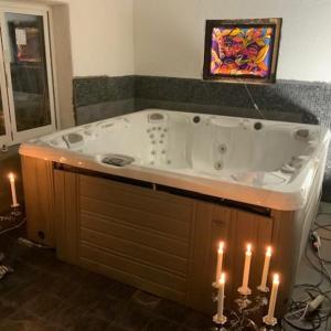 a bathroom with a jacuzzi tub with lit candles at Tystberga Logi in Tystberga